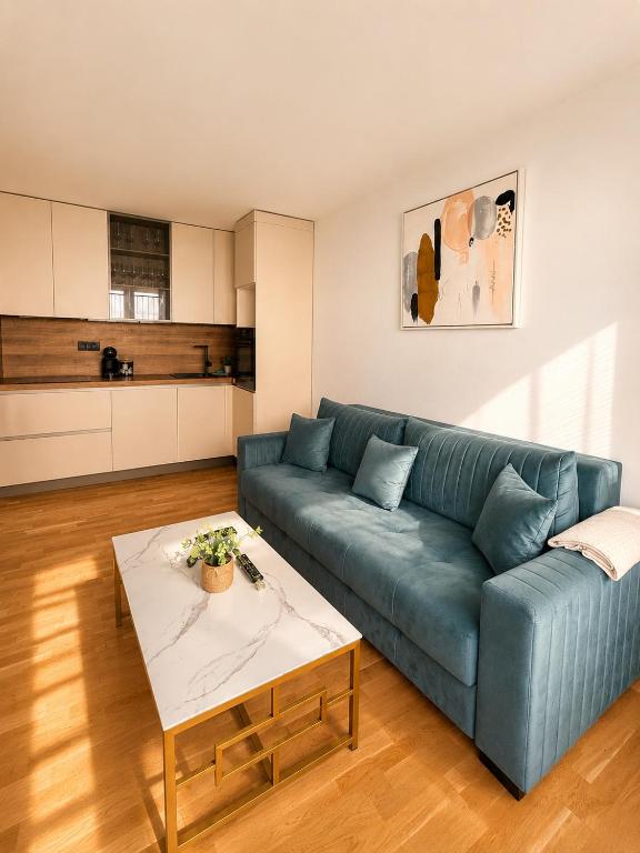 a living room with a blue couch and a table at Sealavie in Koper