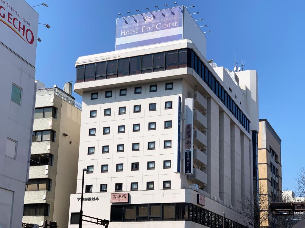 a white building with a sign on top of it at Hotel The Centre Utsunomiya in Utsunomiya