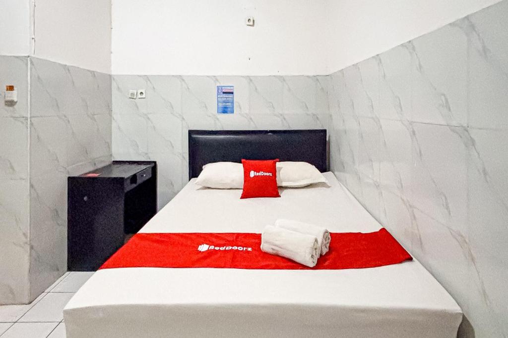 a bedroom with a bed with two towels on it at RedDoorz at Hotel AVA Malioboro in Jetis