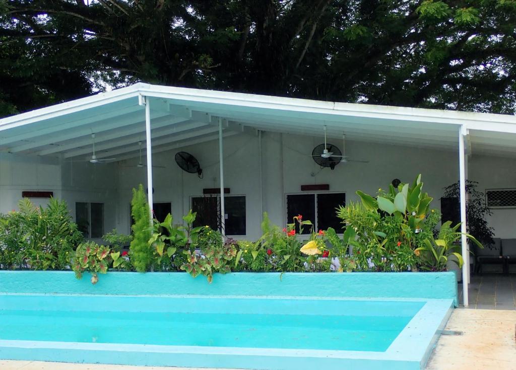 a house with a blue pool in front of it at Coral Quays Resort in Luganville