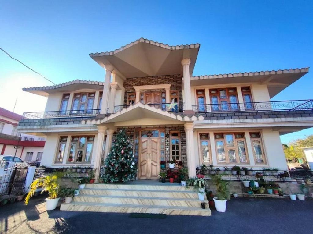 a house with a christmas tree in front of it at Salena Homestay in Cherrapunji