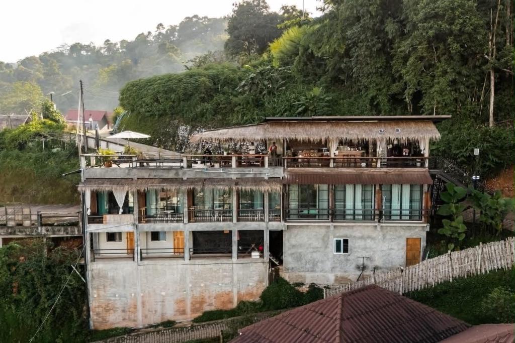 a building with people on the balcony of it at ผาฮี้แลนด์โฮมสเตย์ in Mae Sai