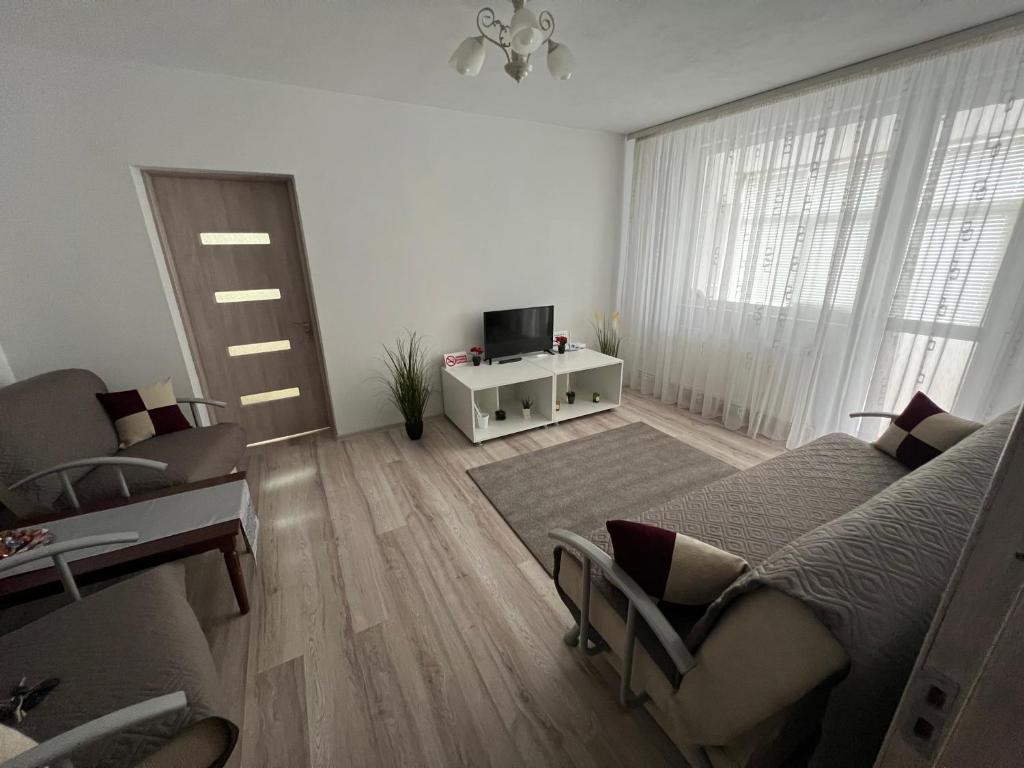 a white living room with a bed and a tv at Margo Apartament cu 2 camere in Târgu Jiu