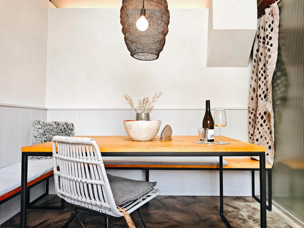 a table with a chair and a bottle of wine at Weinloft III by Weinlofts in Eisenberg an der Pinka