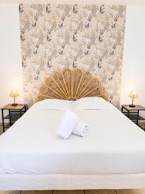 a bedroom with a white bed with a bird patterned wall at Cacatoès in Saint-Aignan