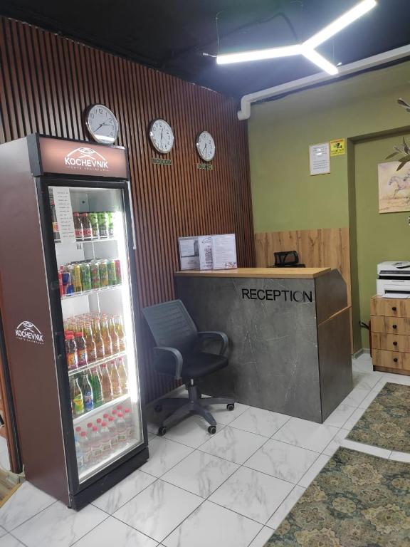 an office with a refrigerator and a chair in a room at Kochevnik capsule Hostel in Almaty