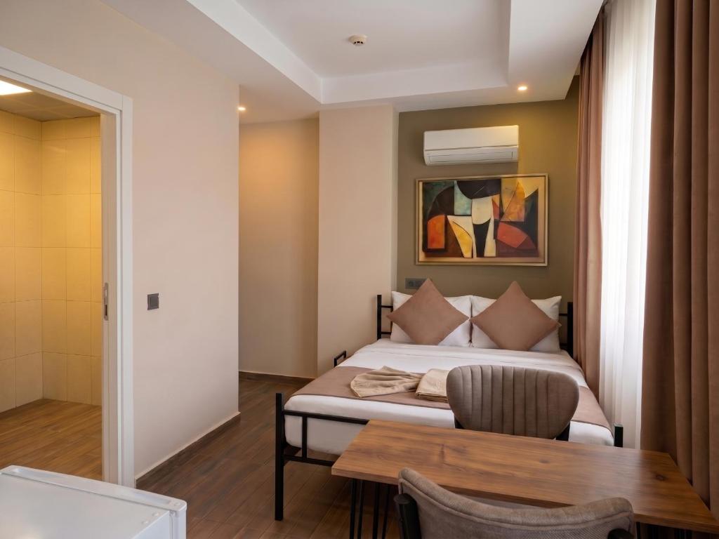a bedroom with a bed and a wooden table at Köşk Boutique Hotel - Old Town & City Center in Antalya