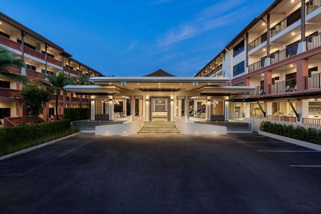 an empty parking lot in front of a building at Kata Sea Breeze Resort - SHA Plus in Kata Beach