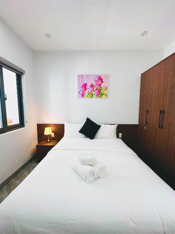 a bedroom with a large white bed and a window at weolhouse in Hue