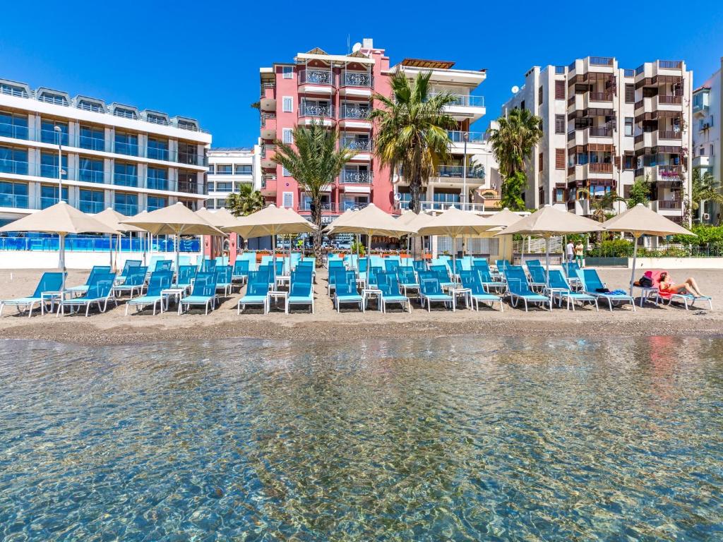 a group of chairs and umbrellas on the beach at Kahveci Alibey Luxury Concept in Marmaris