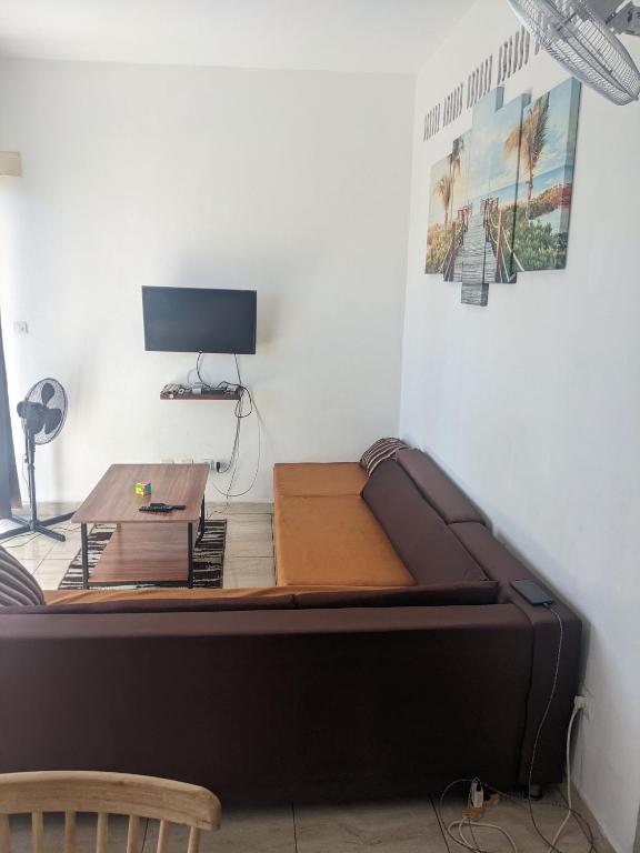 a bed in a room with a desk and a monitor at Appartement VIDA 1 in Mahajanga