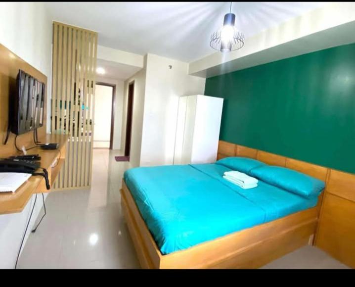 a bedroom with a blue bed and a desk at Horizon101 in Cebu City