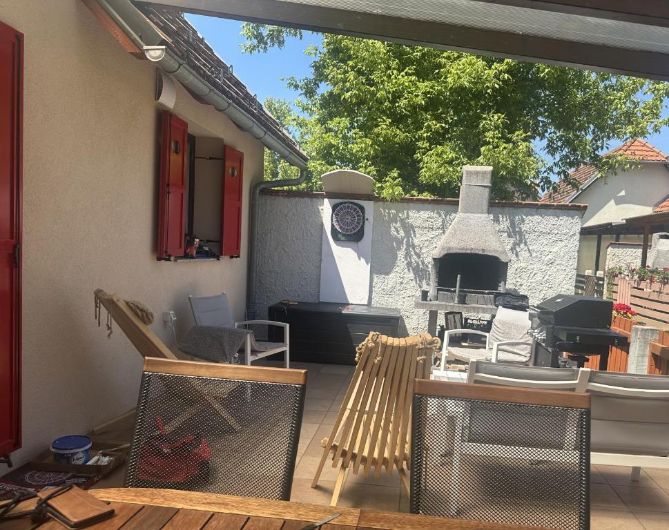 an outdoor patio with chairs and a fireplace at La Hiška Čatež with Tickets - each guest gets 2 entries per day in Čatež ob Savi
