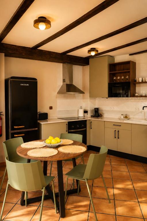 a kitchen with a table and chairs in a kitchen at Alojamientos El Cañico in Moratalla