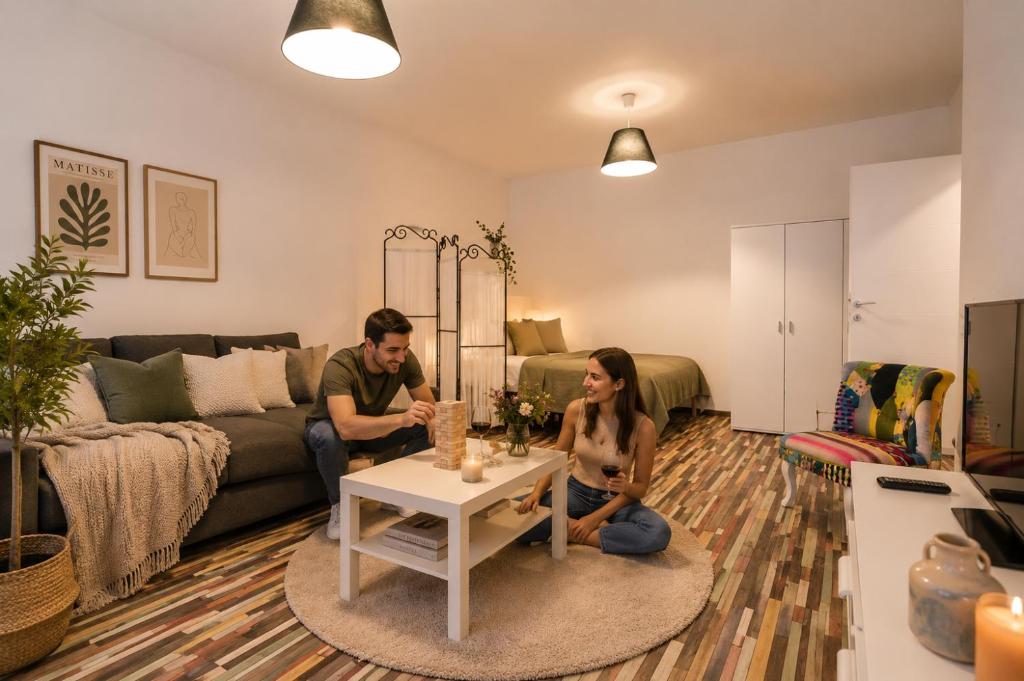 a man and woman sitting on the floor of a living room at Urban Retreat Near Metro & Mega Mall in Bucharest