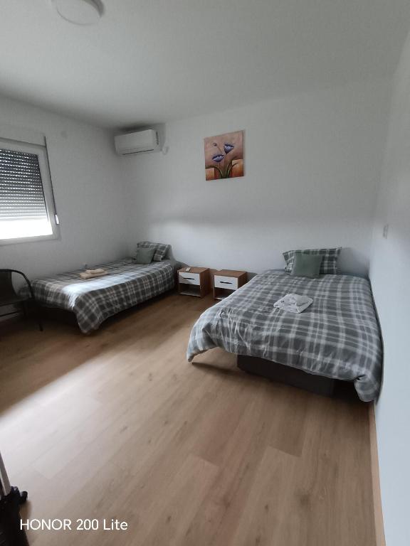 a bedroom with two beds and a window at Soba Za Odmor # in Mladenovac