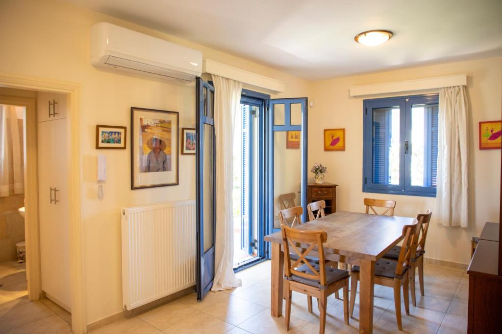 a dining room with a wooden table and chairs at Yasmin House in Perdika