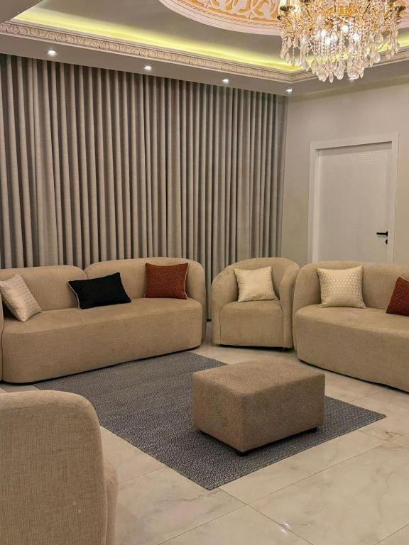 a living room with two couches and a chandelier at شاليهات Luma الفندقية in Bisha Airport