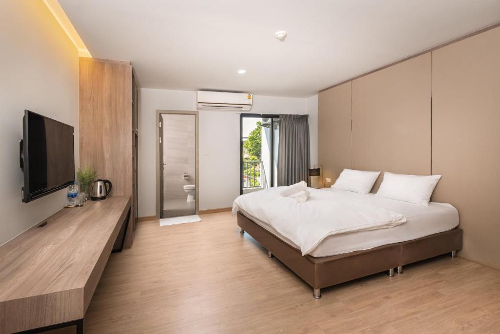 a bedroom with a bed and a flat screen tv at 101 Residence in Amphoe Phra Khanong