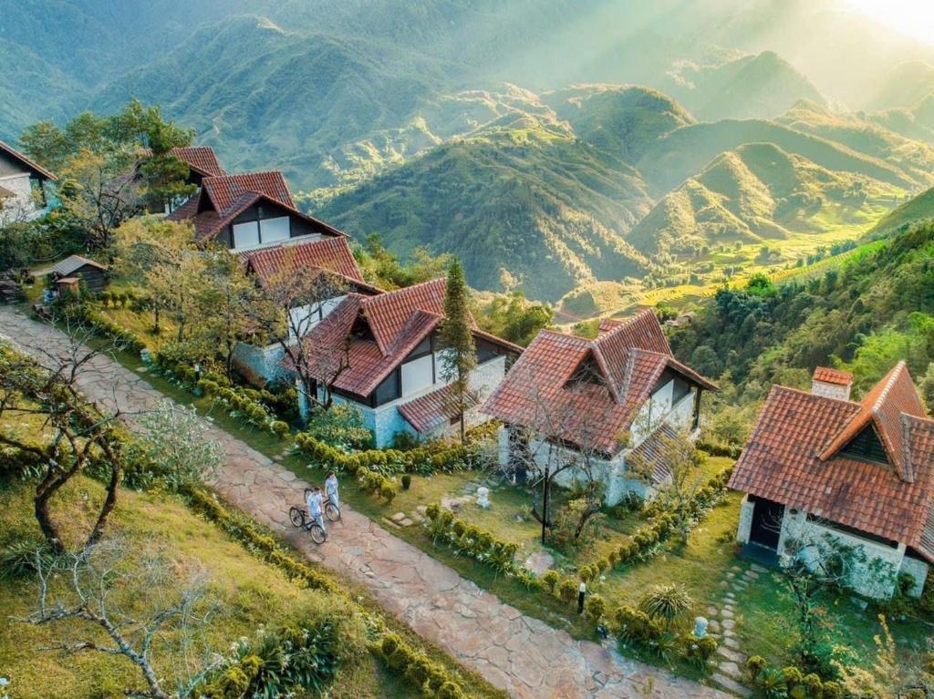 a group of houses on a hill with mountains in the background at Sapa mến khách sapa jade hill in Lao Cai