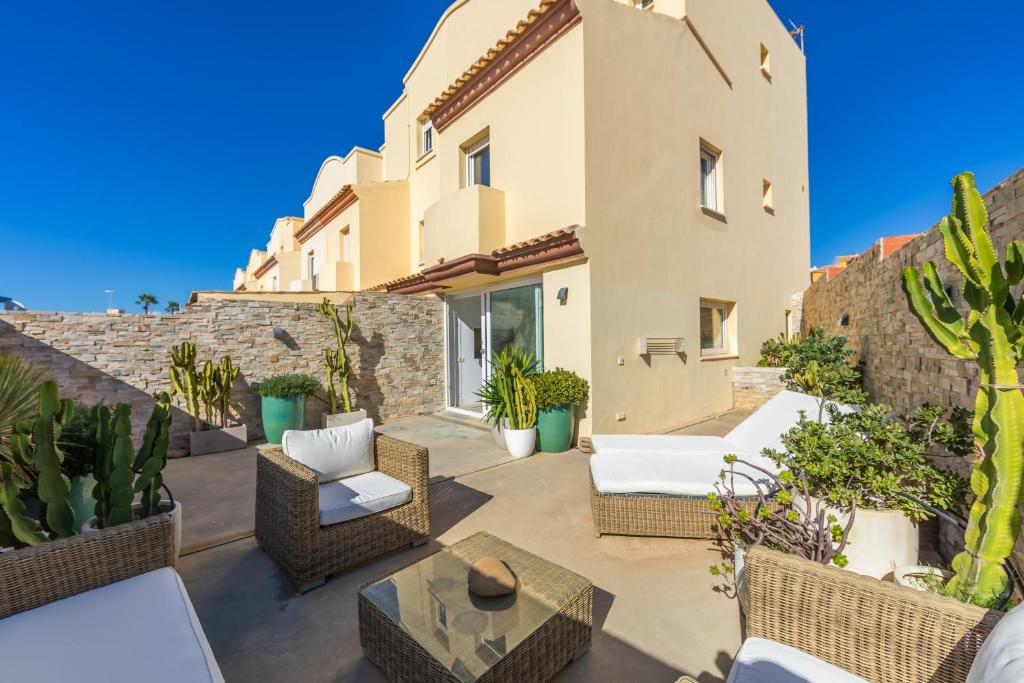a patio with wicker furniture and cactus at Caracolas Luxury House in Tarifa