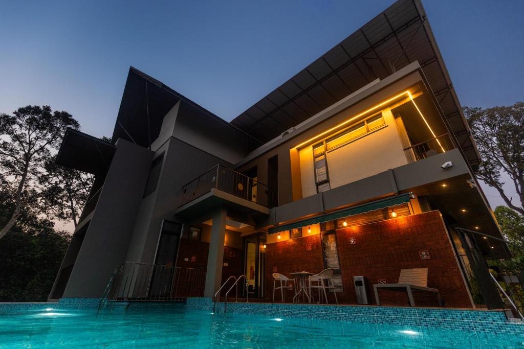 a house with a swimming pool in front of it at Kayn by spynora in Vythiri