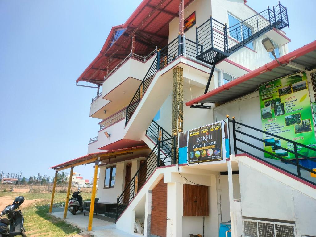 a building with balconies and a sign on it at Loki guest House in Chikmagalūr