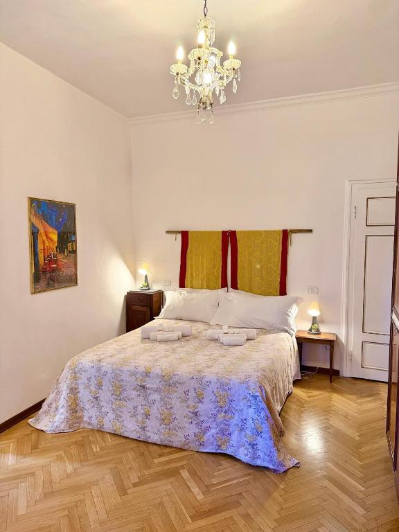 a bedroom with a bed and a chandelier at La Dolce Vita in Pisa