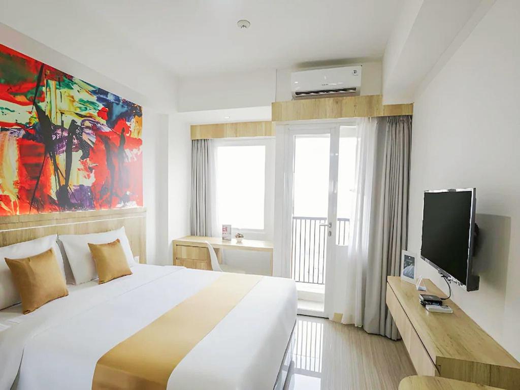 a bedroom with a large bed and a tv at Urban Hotel Serpong in Banten