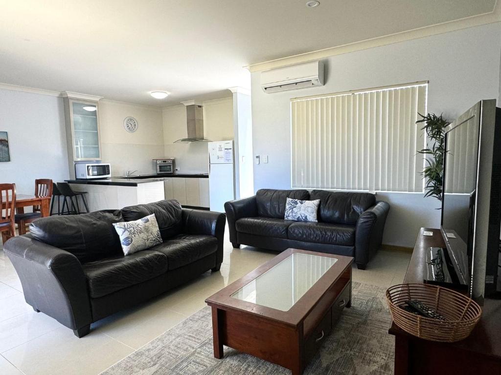 a living room with two leather couches and a coffee table at Unit 24 Seafront Estate in Jurien Bay