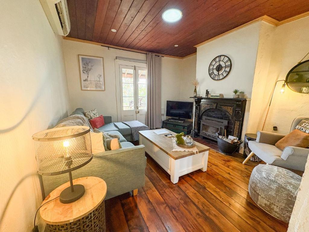 a living room with a couch and a fireplace at Gladstone House in Beechworth