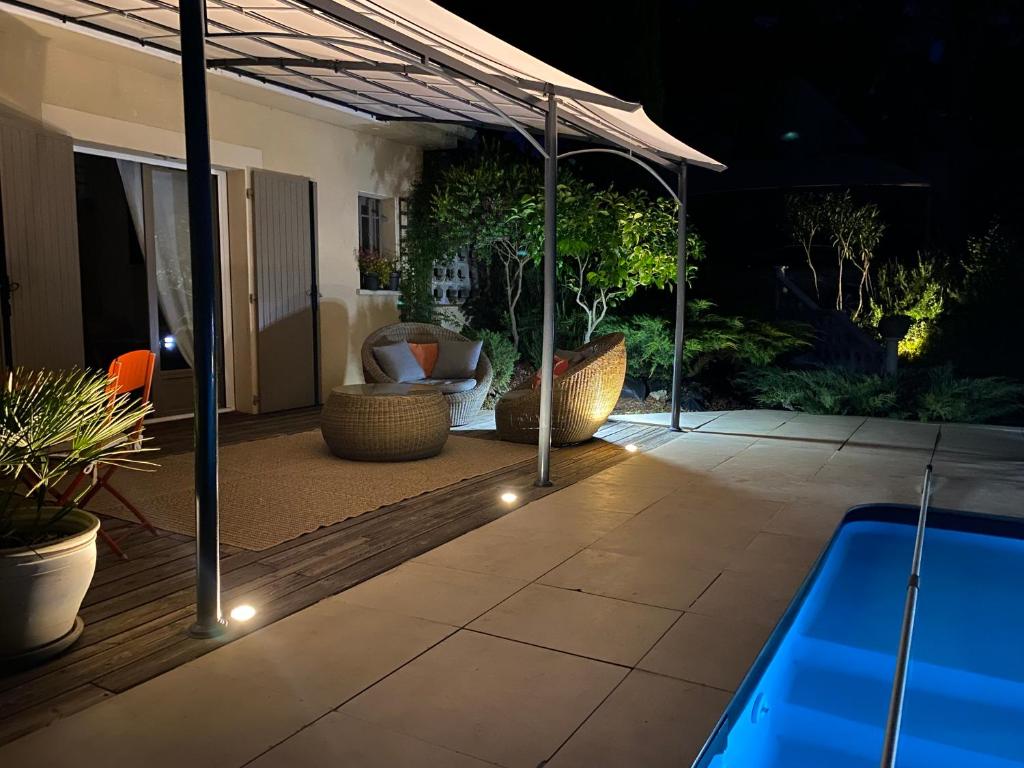 a patio with a swimming pool at night at la passerelle du couchant in Langlade