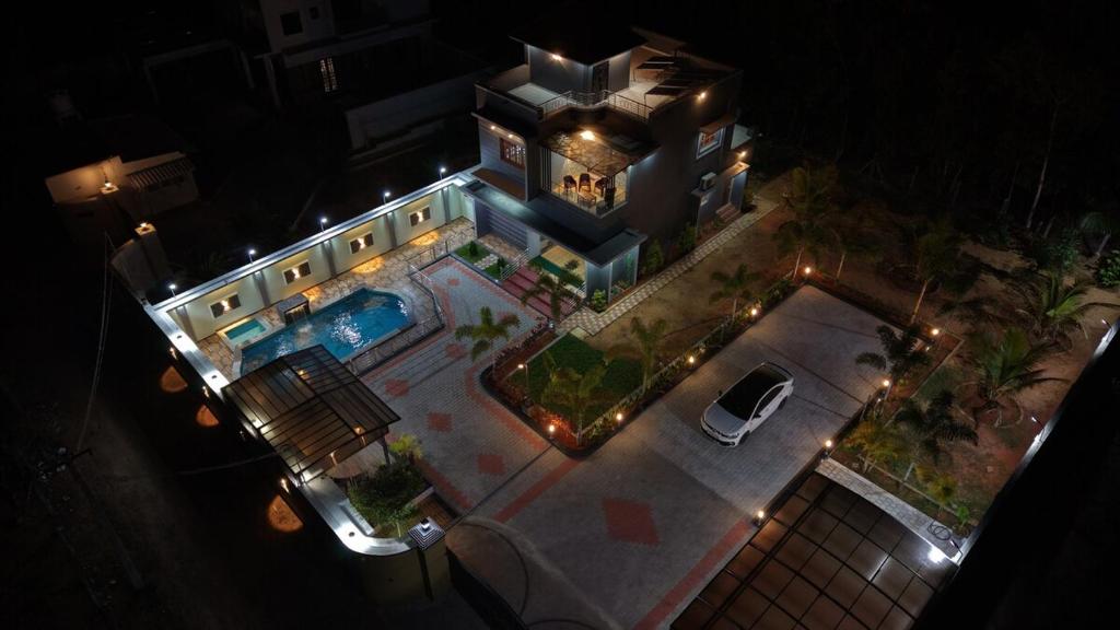 an aerial view of a house with a swimming pool at night at Sky Haven Resort - Private Pool Villa near ECR in Kottaikadu