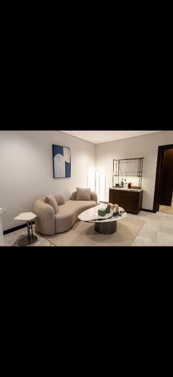 ein Wohnzimmer mit Sofa und Tisch in der Unterkunft ريف دنن in Al-'Ula