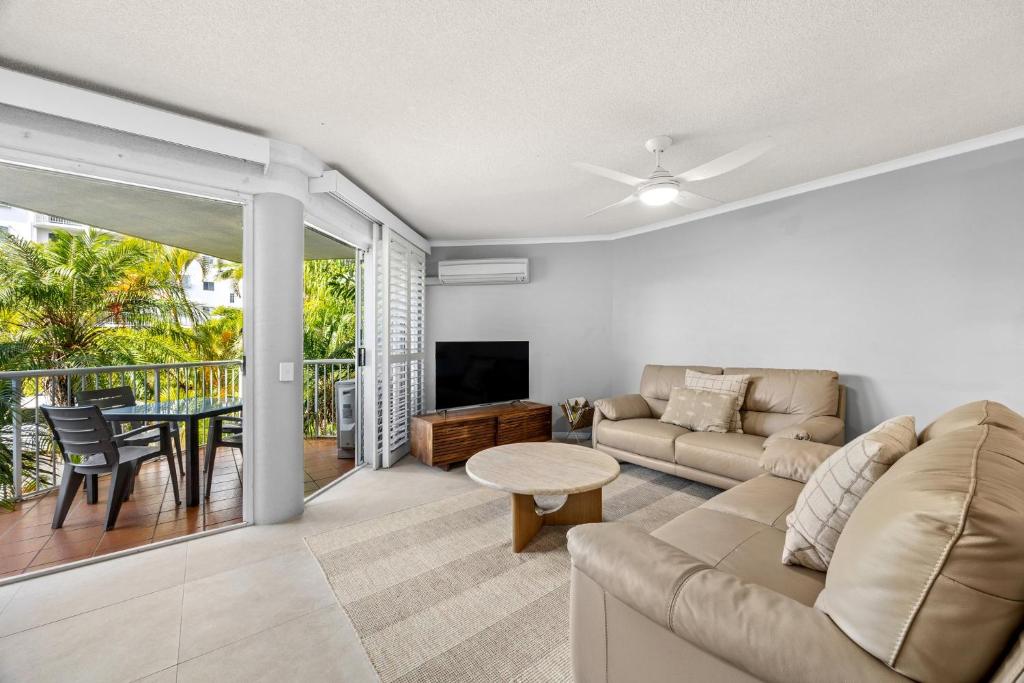 a living room with a couch and a table at Dockside Apartments Mooloolaba-Pool renovation from 1st of June-12th of August in Mooloolaba