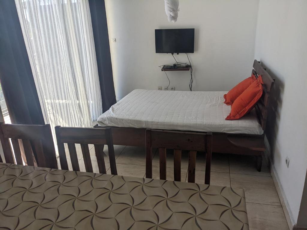 a small room with a bed and a television at Appartement VIDA 2 in Mahajanga