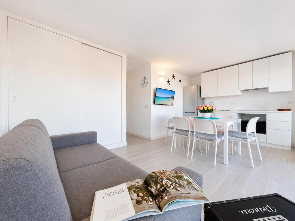 a living room with a couch and a table at Renew Terrace F with Swimming Pool 70m from the Beach in Baja Sardinia