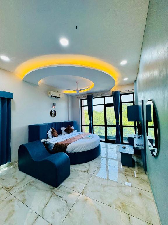 a bedroom with a bed and a couch in it at Hotel JD Fortune in Anand