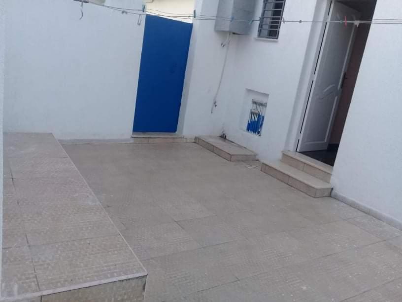 a room with a blue door on a white building at Mon cœur Gris-Or in Rejiche