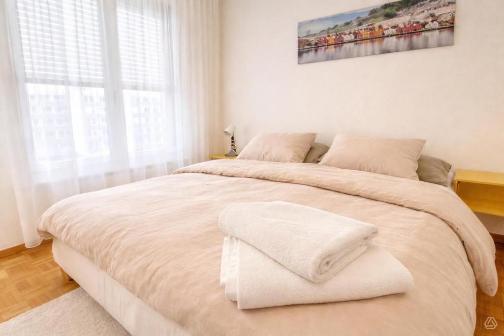 a bedroom with a large bed with white sheets at Appartement Coeur de Ville in Lausanne