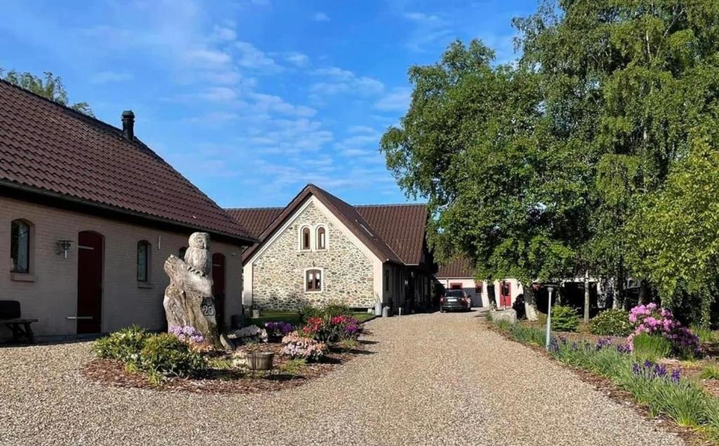 a house with a statue in front of a driveway at Holmens Guesthouse in Lemming
