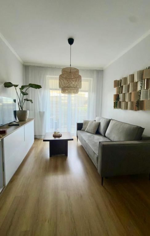 a living room with a couch and a table at Apartament Przytulny 2, self check-in, blisko lotniska in Trzebownisko