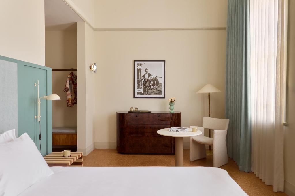a bedroom with a bed and a table and a chair at Owston Hotel in Fremantle
