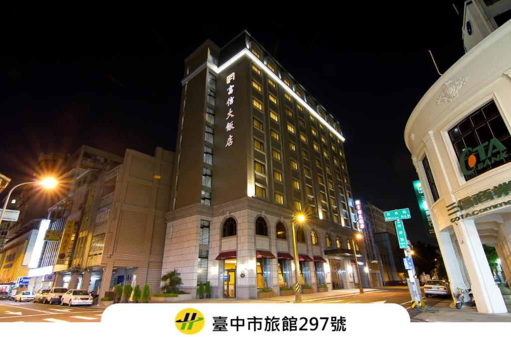 a lit up building on a city street at night at Fushin Hotel Taichung in Taichung
