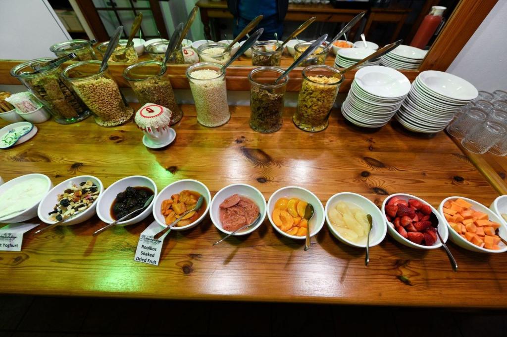 a wooden table topped with bowls of different types of food at Blommenberg in Clanwilliam
