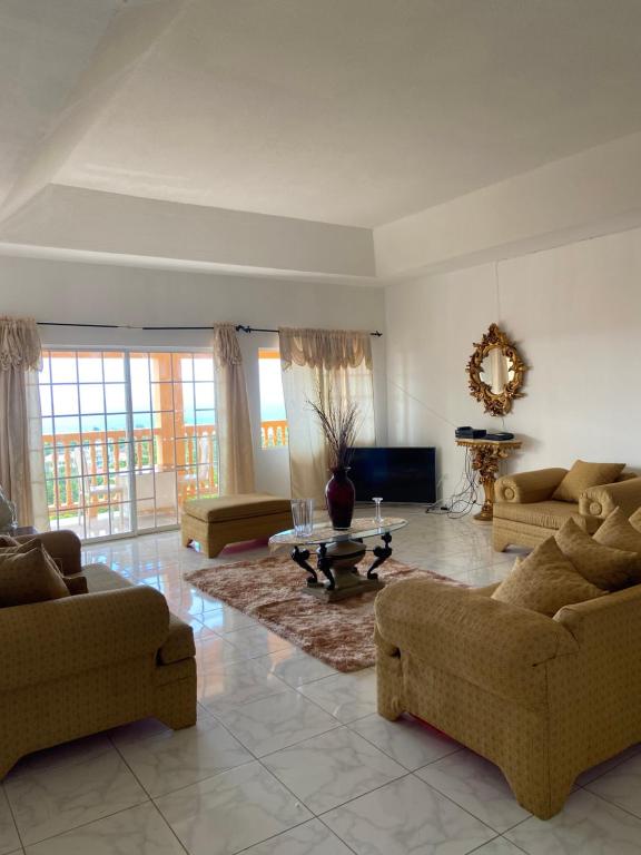 a large living room with couches and a tv at Vista Oceanica in Ocho Rios