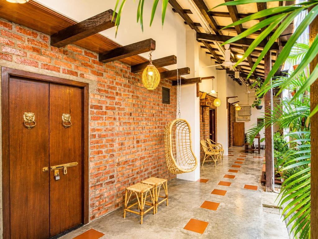 a hallway with a brick wall and a wooden door at Palm Mansion Boutique Suites in George Town