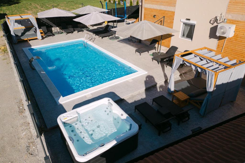an overhead view of a swimming pool with chairs and umbrellas at Apartmani Dejavu na Drini in Ljubovija