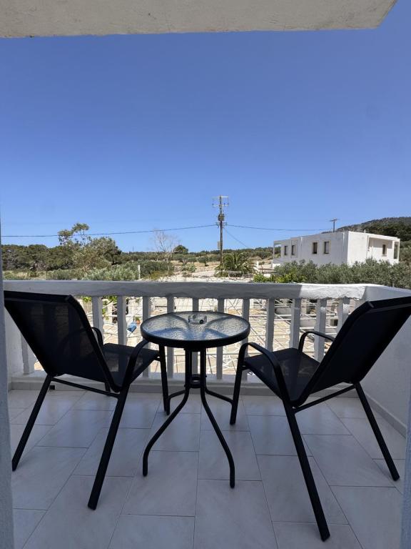 a table and two chairs on a balcony at Nikos Apartments in Lefkos Karpathou