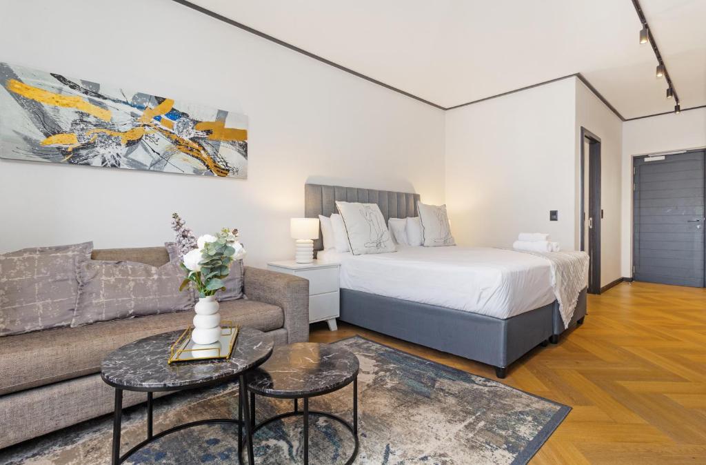 a living room with a bed and a couch at Nine Palms Studio Retreat Century City in Cape Town
